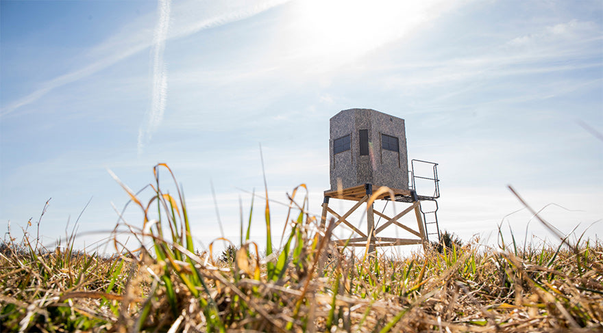 an elevated hunting blind in a grass field