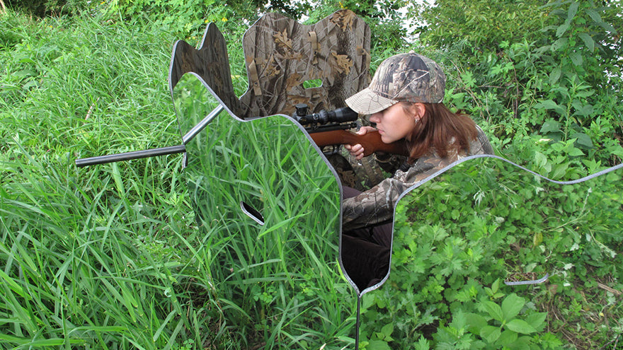 hunter hidden behind camouflaged blind