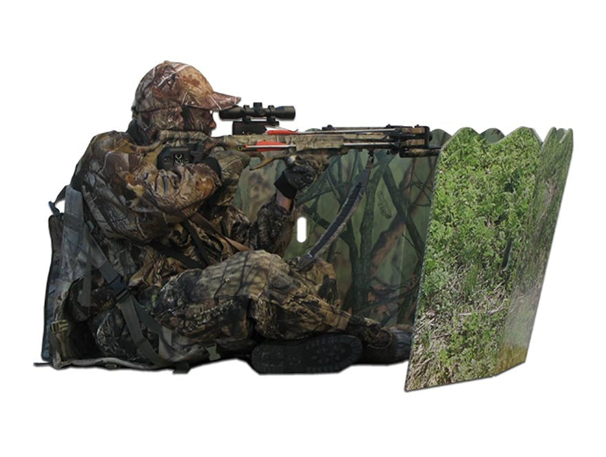 hunter using rifle behind blind cover