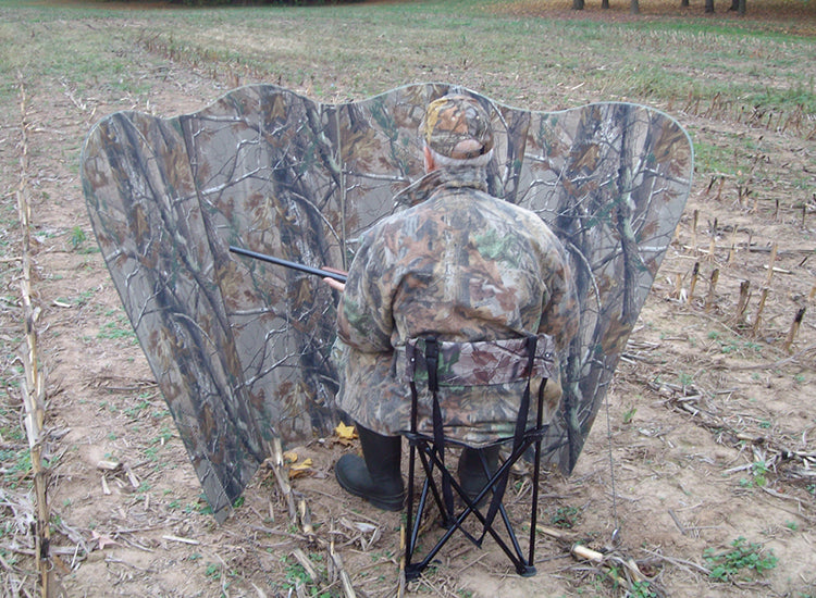 a man sitting behind a mirror hunting blind