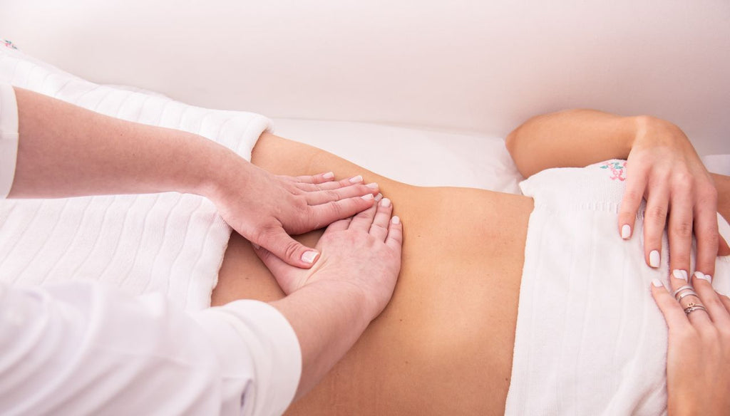 Two hands doing a lymphatic massage to a woman