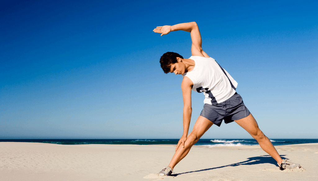Man stretching out at the beach with good energy