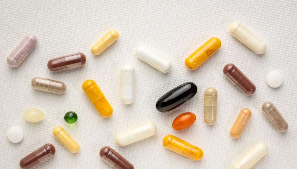 Lots of capsules of vitamin and supplements on a white table