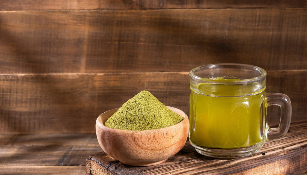 Moringa tea and moringa powder on a wood background