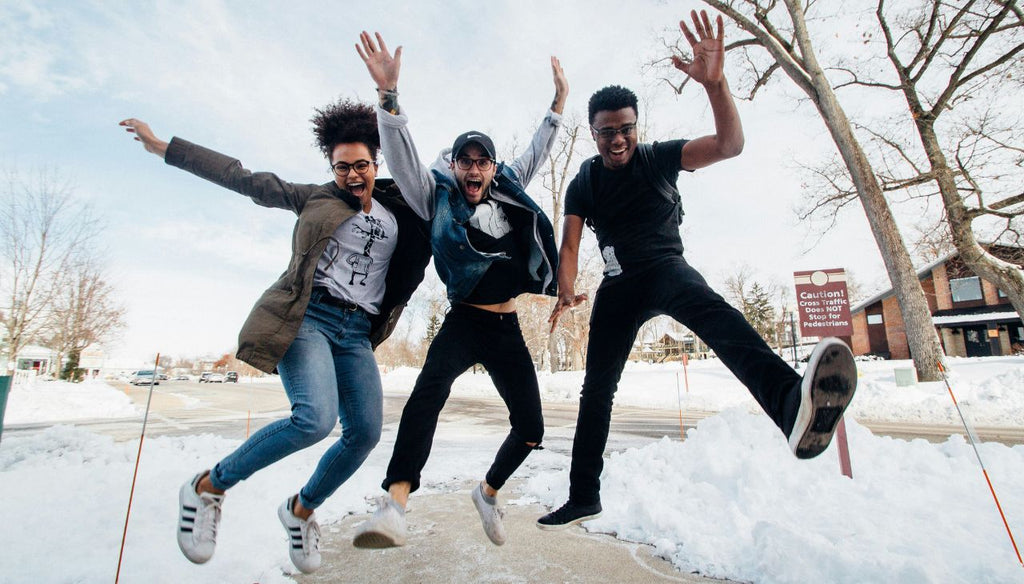 Three men jumping on ground having fun