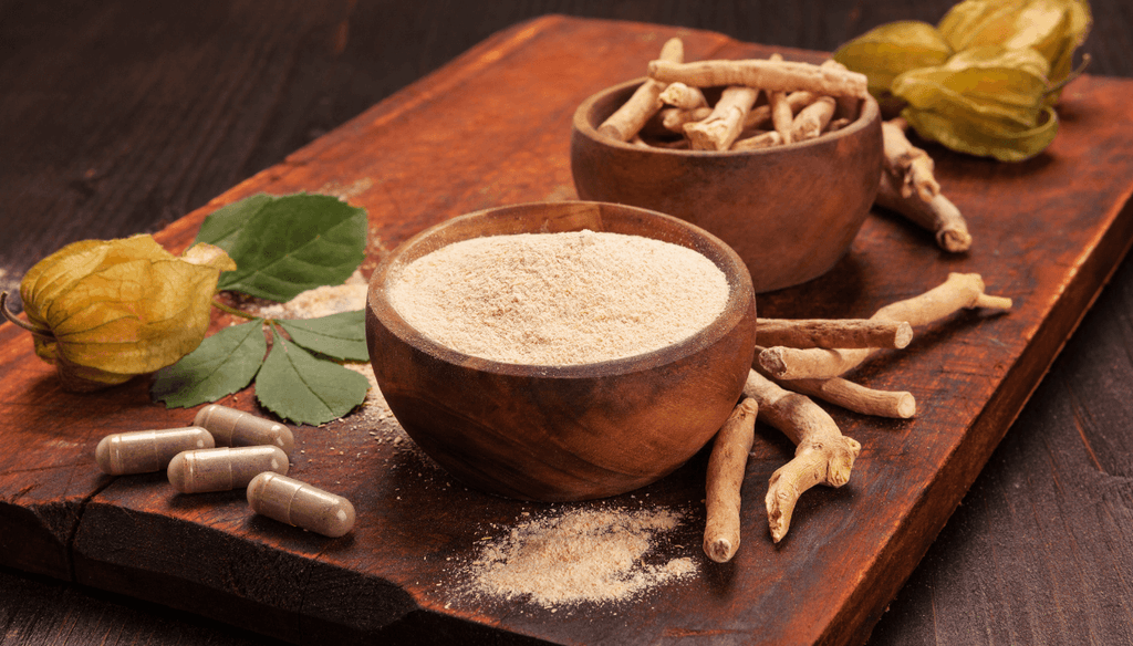 Ashwagandha roots, powder and capsules on a wood table