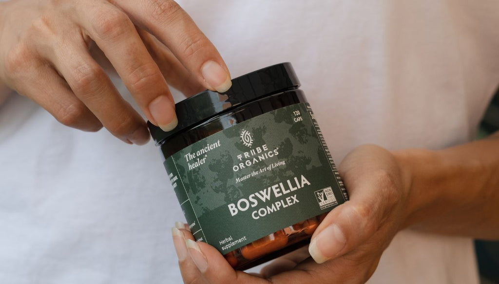 Two hands holding a Tribe Organics Boswellia Complex bottle