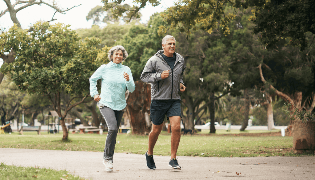 An older couple running for exercise at a park