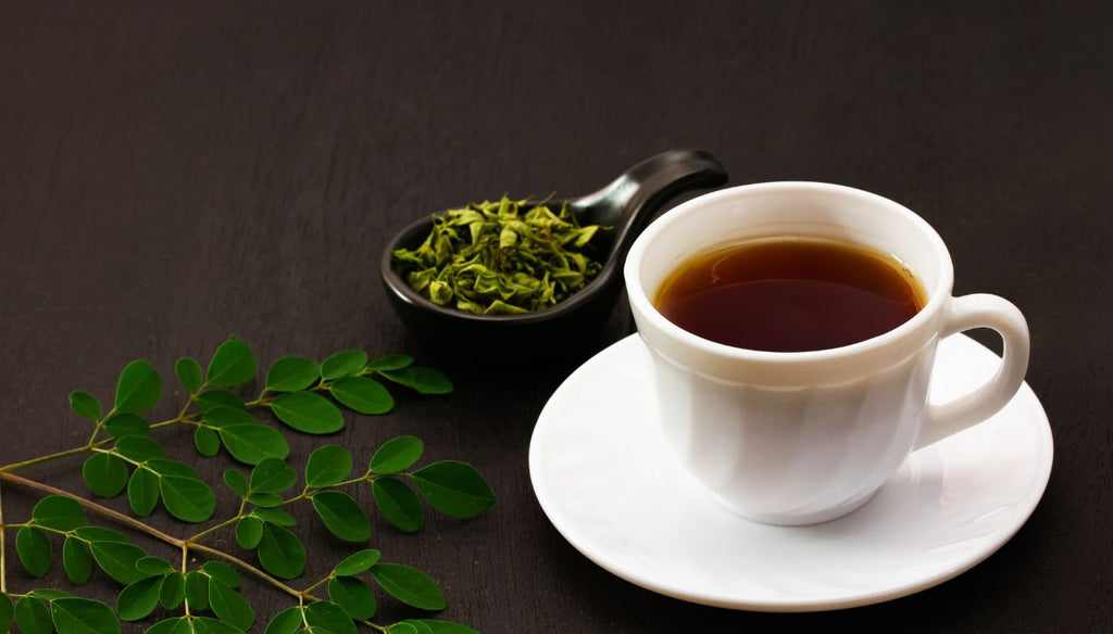 cup of moringa tea on a black table