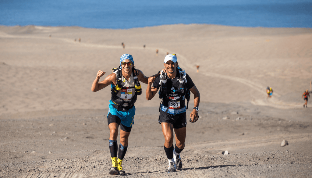 Two men running on a marathon with ocean view