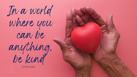 In a world where  you can be kind quote. Pair of hand holding a heart. 