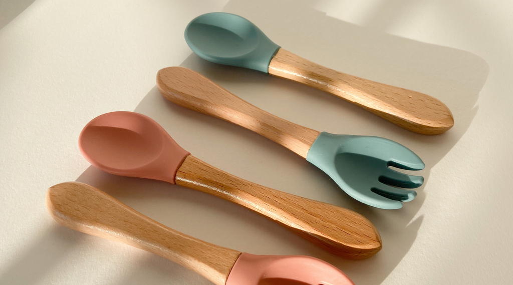 row of silicone spoons and forks with wooden handles laid flat 