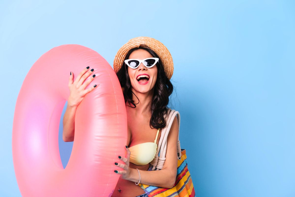 Femme avec une bouée gonflable, portant des lunettes de soleil et un bikini menstruel