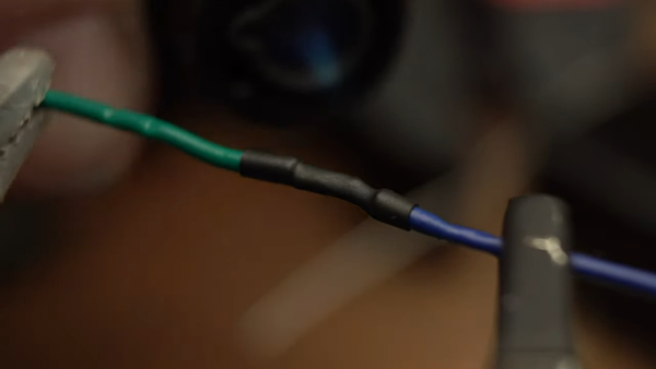 applying heat shrink to our newly joined wires