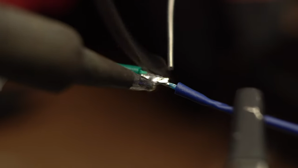 soldering wires together on a pair of helping hands