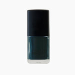 A bottle of Sea queen nail polish by Paint Nail Lacquer against a white backdrop, this shade is a dark teal green.