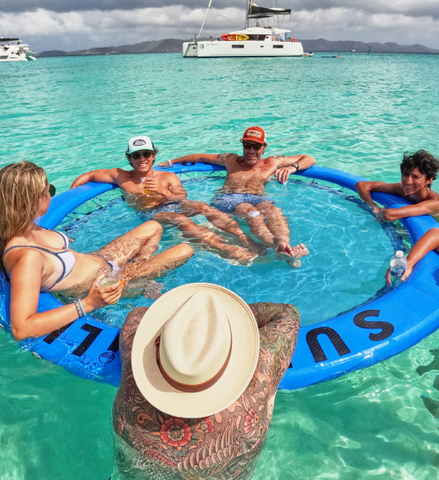 Group of people relaxing in sunchill floaty with firm rim and cup holders