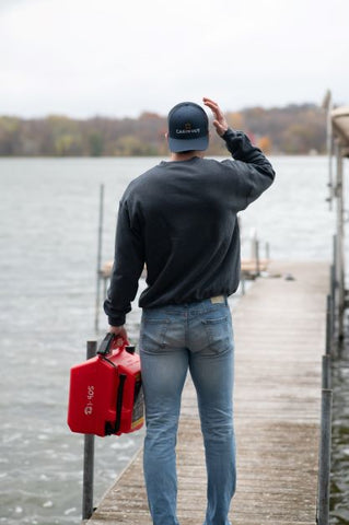 On the dock putting gas in the boat at the lake cabin