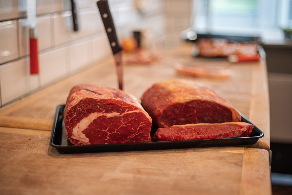 Bild von Ribeye- und Sirloin-Steaks auf einem Teller in der Küche