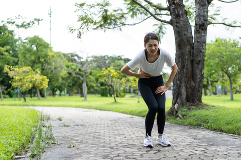 woman with hip pain on running track