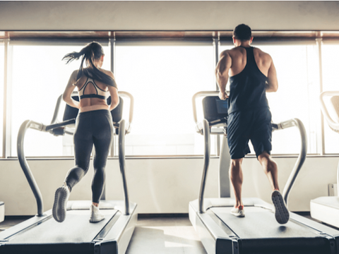 woman and man on treadmill running side by side