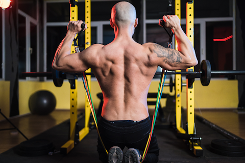 man's bare back big muscles while lifting weights