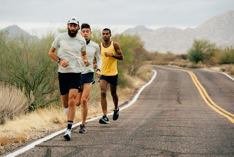 three men running on side of road exercise