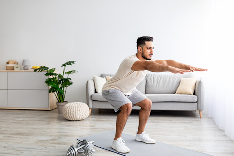 A man in his lounge doing squats