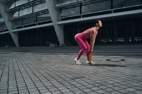 A lady doing banded single leg deadlifts