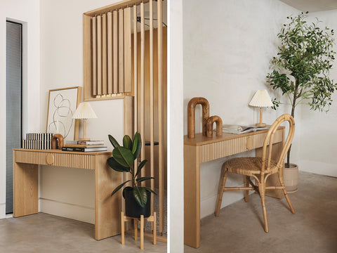 A reeded wood console table styled and used as a desk and console table.