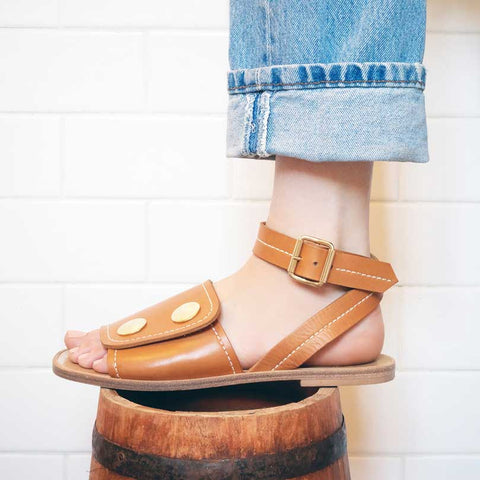 tan cognac leather sandals worn with cuffed Levi's denim