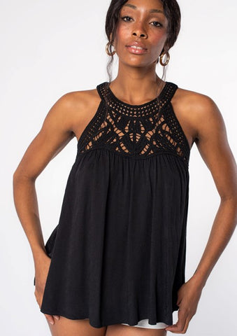 A model wearing a black high neck tank top with crochet knit detail at the yoke