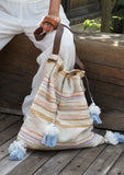 [Color: Natural Multi] An ultra bohemian drawstring tote bag in a striped canvas. Featuring a drawstring top, snap closure, and long leather strap.