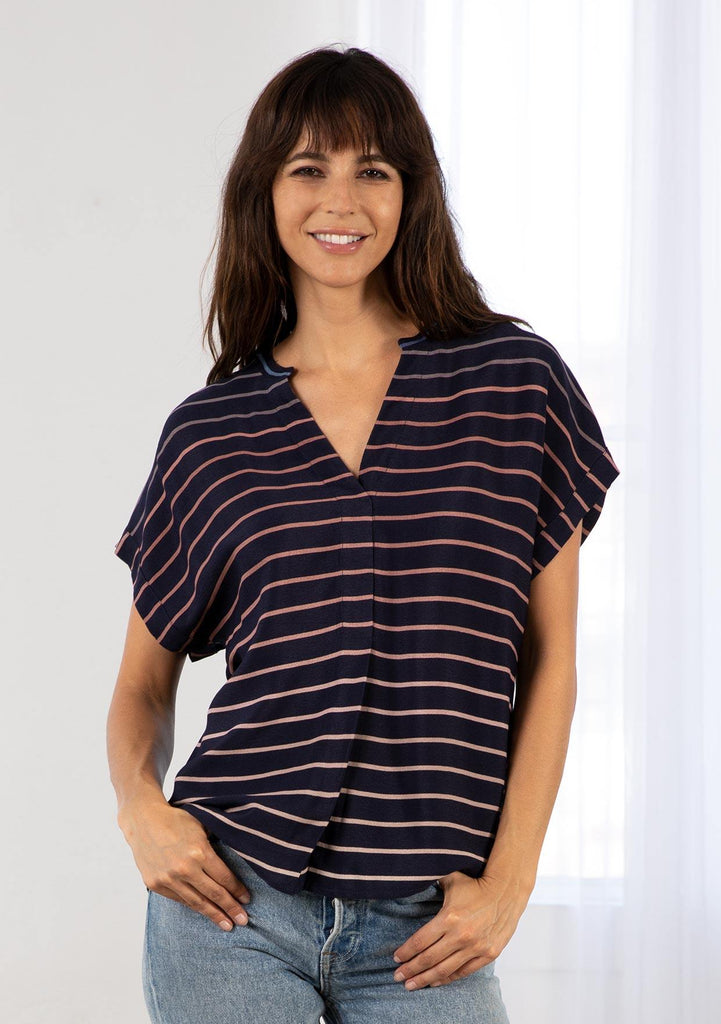 [Color: Navy/Blue] A model wearing a classic navy blue popover top in a gradient stripe print. Featuring a banded collar, short dolman sleeves with a folded cuff, and a sophisticated front pleat.