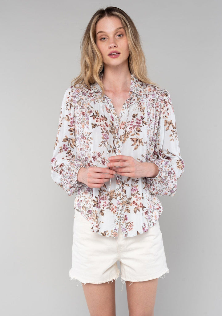 [Color: Mint/Rose] A half body front facing image of a blonde model wearing a vintage inspired bohemian blouse in a pink mixed floral print. With long sleeves, a collared neckline with ties, a self covered button front, and a flowy relaxed fit. 