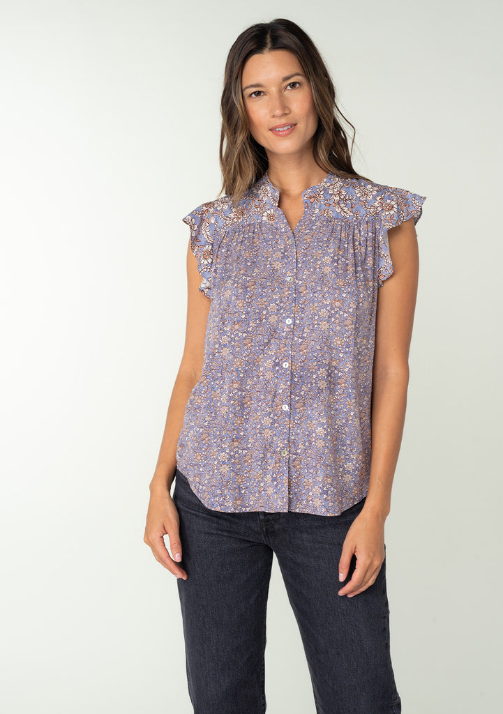 [Color: Grey/Natural] A front facing image of a brunette model wearing a best selling Helpone clickaway button front top in a grey and natural floral print. With short flutter sleeves and a ruffled neckline. 