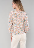 [Color: Natural/Coral] A back facing image of a blonde model wearing a bohemian blouse in a natural and coral floral print. With long sleeves, a round neckline, a self covered button front, and a tie front waist. 