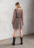 [Color: Black/Coral] A model wearing a dreamy sheer chiffon bohemian black and coral paisley mini dress. With contrast crochet trim, a baby doll dress silhouette, and long sleeves. A flowy Fall bohemian mini dress.