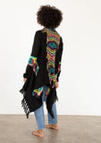 [Color: Black/Multi] A model wearing a black chunky knit cardigan with a multicolor shaggy yarn detail. Featuring a fringed waterfall hemline and an open front.