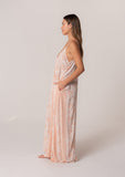 [Color: Natural/Peach] A side facing image of a brunette model wearing a best selling pink bohemian printed maxi dress. With adjustable spaghetti straps, a deep v neckline in the front and back, a flowy, oversize cocoon fit, and side pockets. 