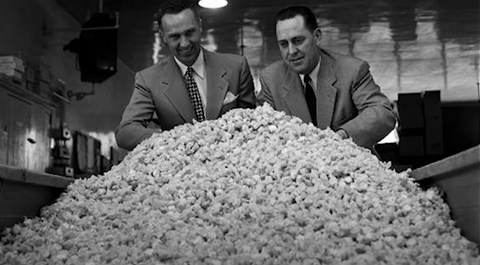 Salt Water Taffy History | Founders of Taffy Town behind a large pile of salt water taffy