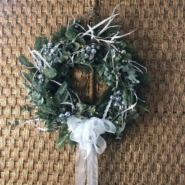 The Twinkling door garland gives a luxurious, fun and festive welcome to your home! Featuring traditional spruce, eucalyptus and silver toned foliage and a complimentary sparkly white ribbon. Playful silver baubles and a mini set of lights complete the lavish, joyful masterpiece!