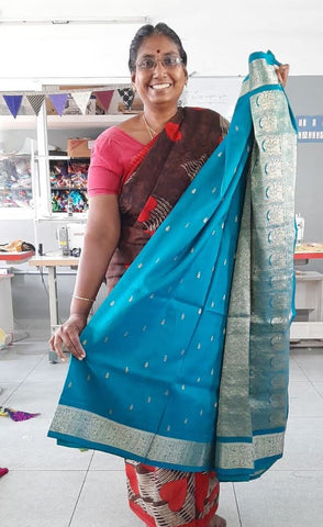 woman standing holding up sari and smiling