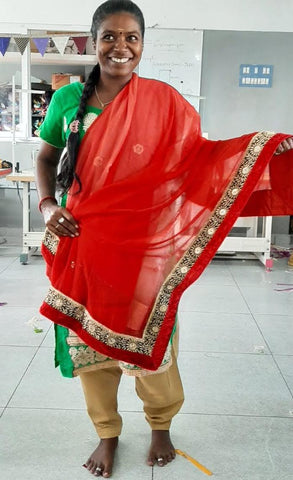 woman standing holding up sari and smiling