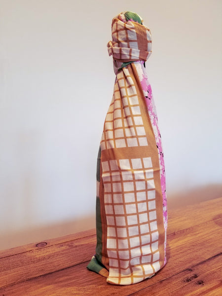 wine bottle wrapped in sari gift wrap on wooden table