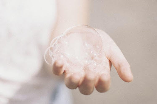 Soap bubbles in a person’s hand.