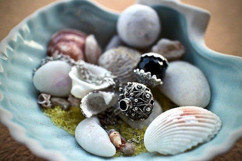  charm necklace and shells in a bowl 