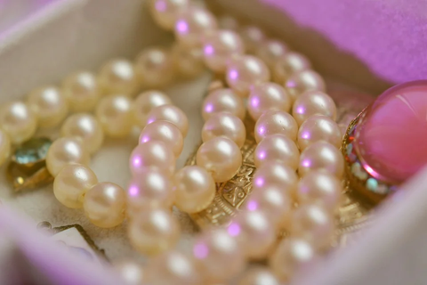  a pile of white pearl necklaces on a silk cloth