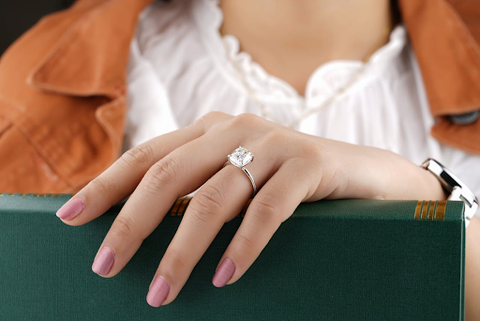 A woman wearing a large diamond engagement ring.
