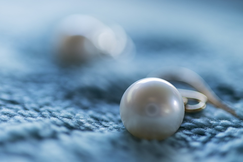 white pearl sitting on a blue cloth